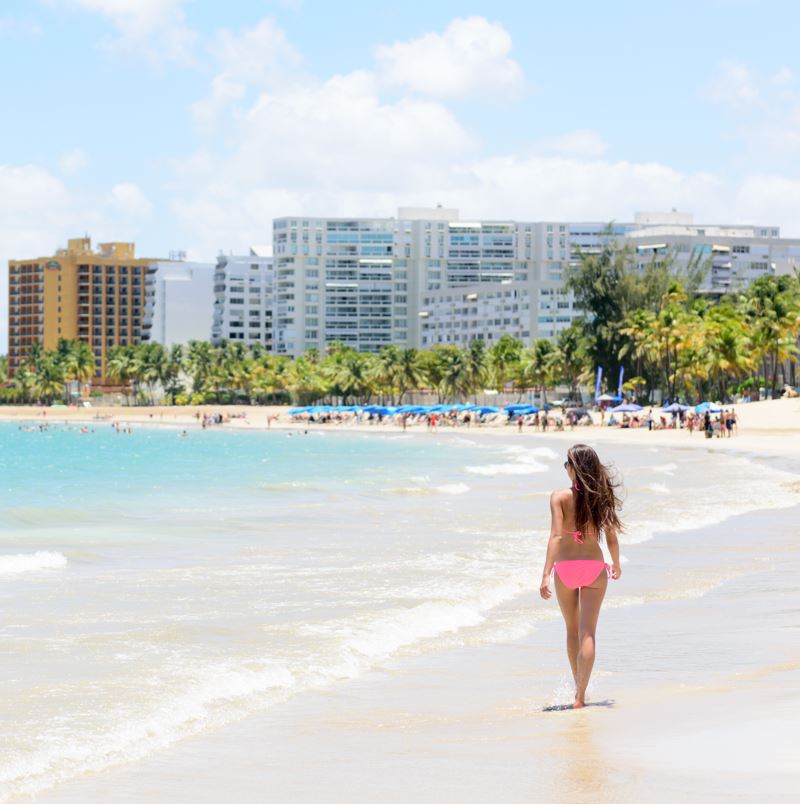 Woman walking along beach in puerto rico