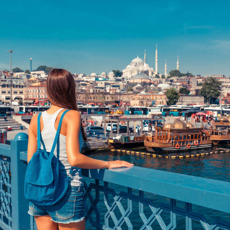 Young Female Tourist Pictured With Her Backpack As She Stands On Galata Bridge Looking At The Historical Peninsula Of Istanbul, Turkyie, Turkey, Eurasia, Middle East, Eastern Europe