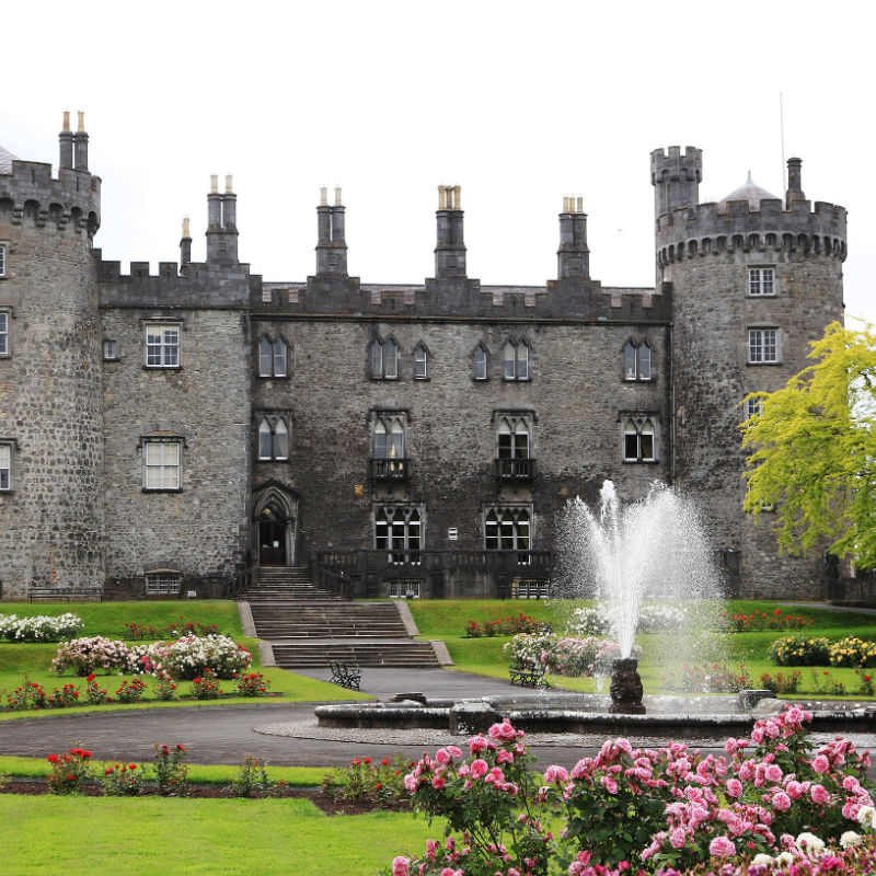 a fountain sprays water into the air in front of the Kilkenny Castle