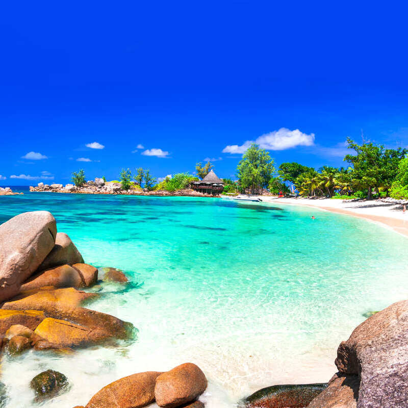 Beautiful Sandy Beach With A Teal Colored Ocean In Seychelles, Africa