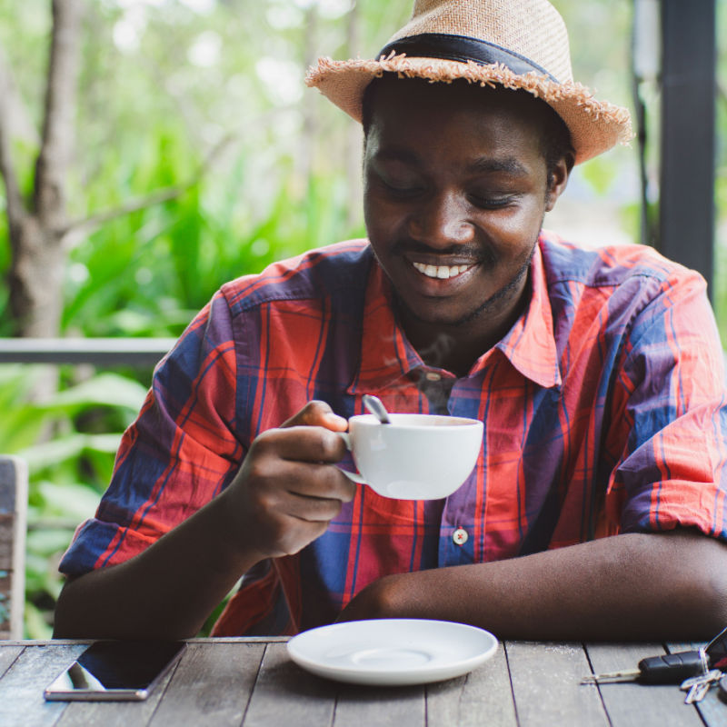 African man holding a hot of coffee with smile and happy