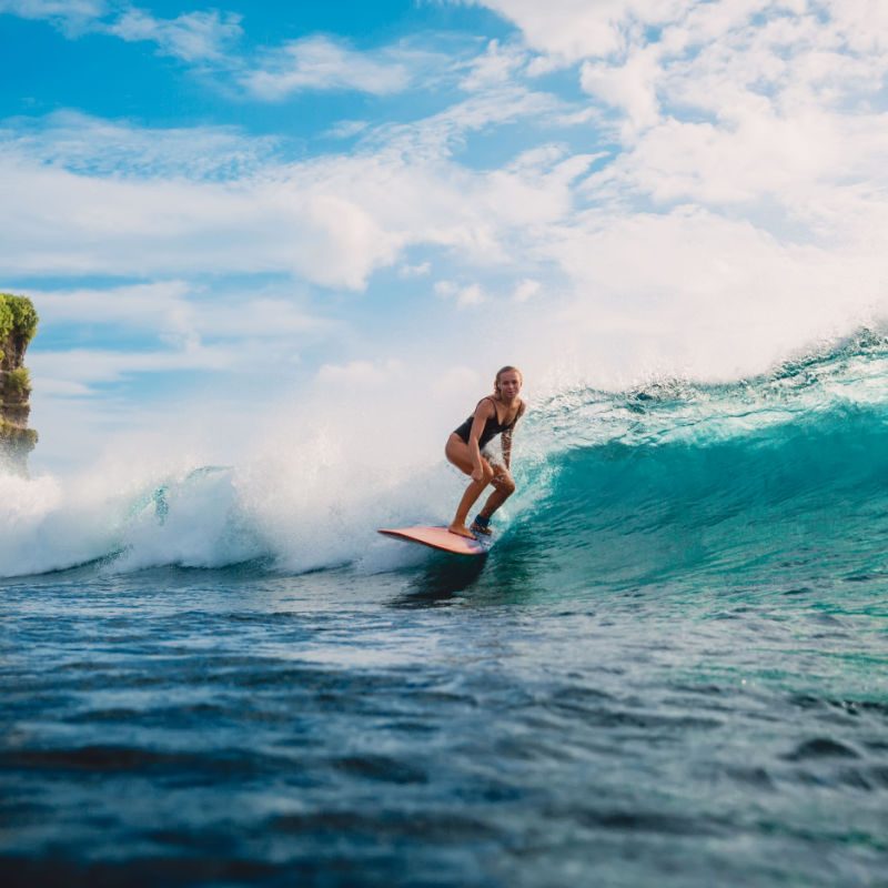 Surf girl on surfboard. Woman in ocean during surfing in Bali. travel