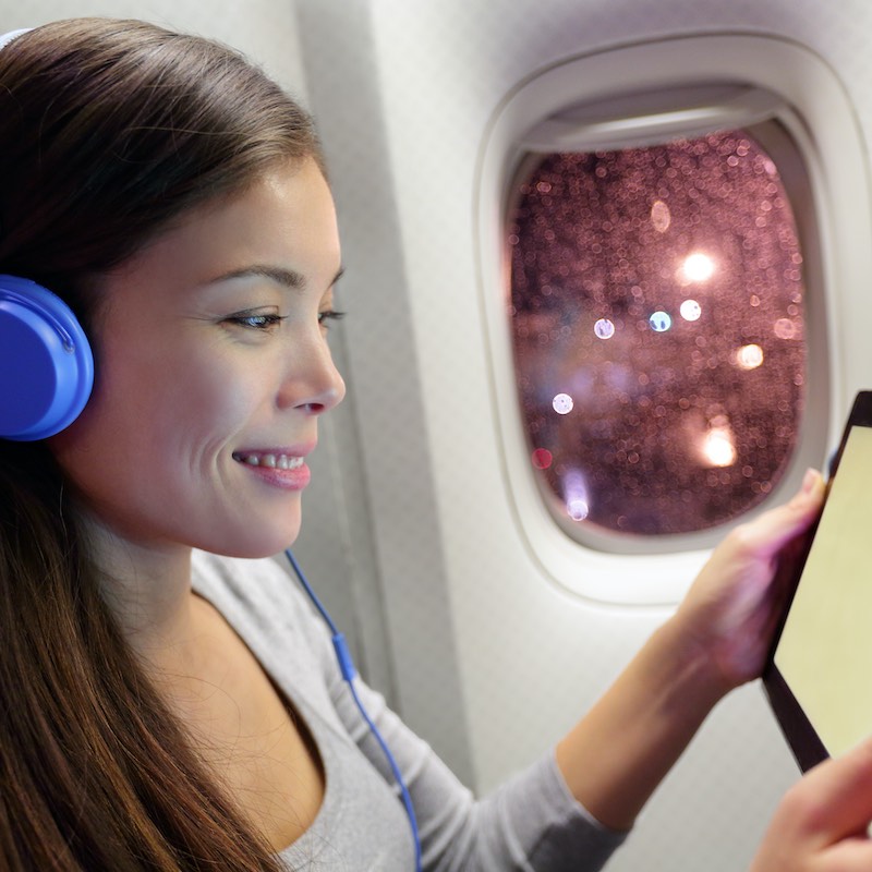 woman looking at her tablet on a plane