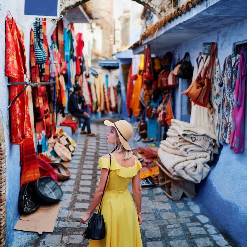 Woman with yellow dress exploring streets in Chefchaouen, Morocco
