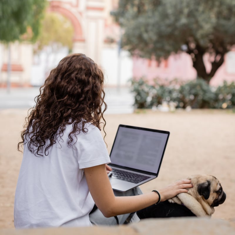 woman digital nomad on laptop in barcelona with cute dog