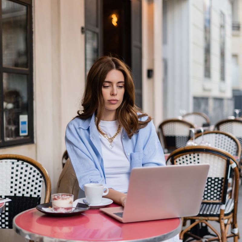 digital nomad working on a laptop in a Paris cafe, France